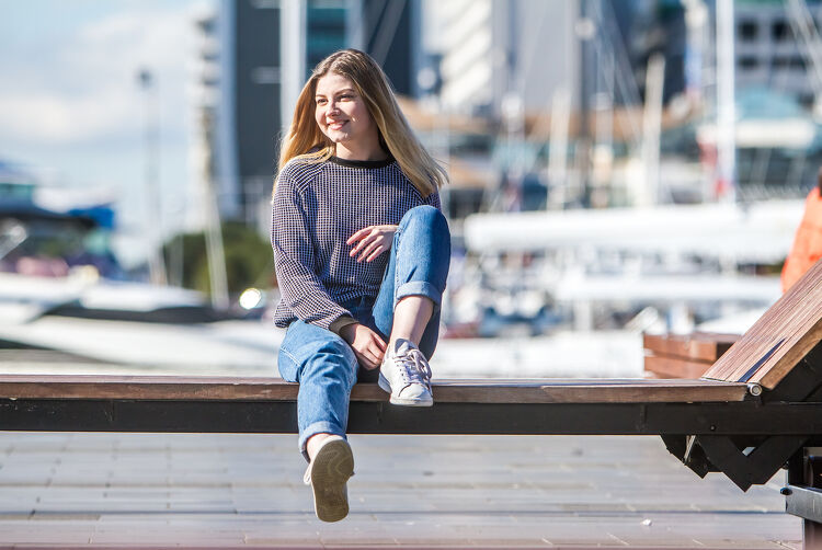 Girl Sitting on a Bench by the Harbour