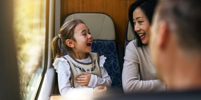 Mother and Daughter Laughing Together on a Train Ride Through Canterbury