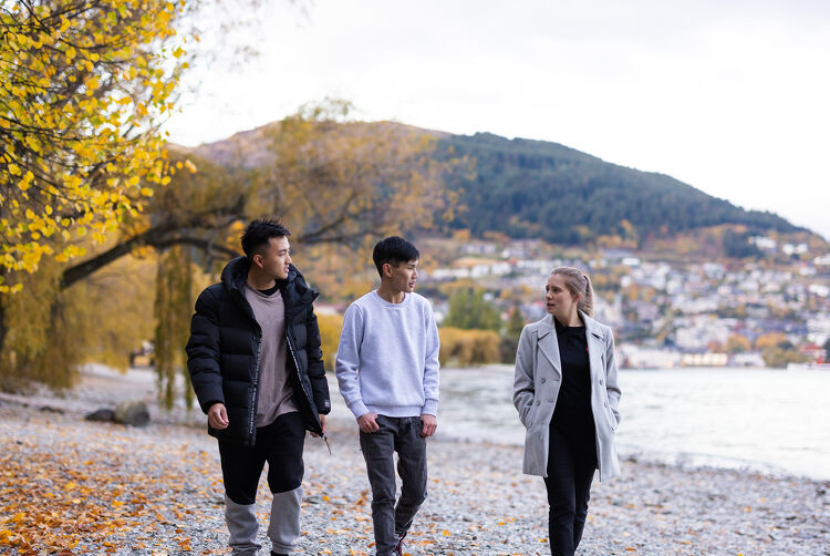 Group of people walking beside a lake