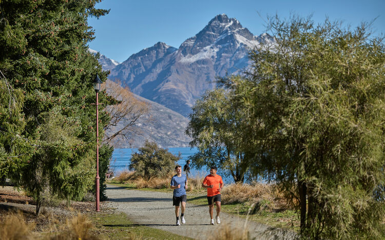 Two people running along gravel path